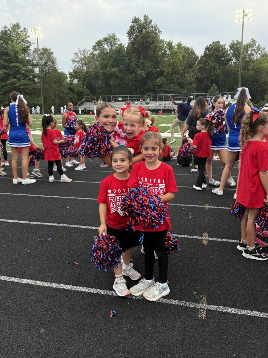 Junior cheerleader Winnie Kelly smiles with Cold Spring Elementary School students who participated in cheer's annual mini camp. "I had a great time and hope they did too," Kelly said. Photo courtesy Joanna Wallace