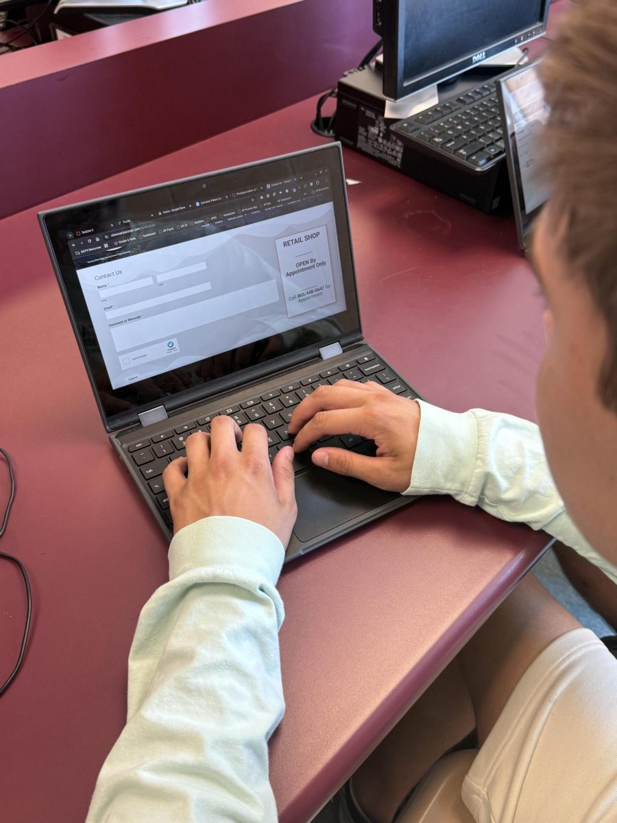 Senior Bryson Filbert fills out a job application for the same store where English teacher Zachary Lowe first worked. Lowe taught young children the basics of guitar during his time at the store. "I mostly worked with young kids who were just getting started. I've never been an advanced player," Lowe said. 