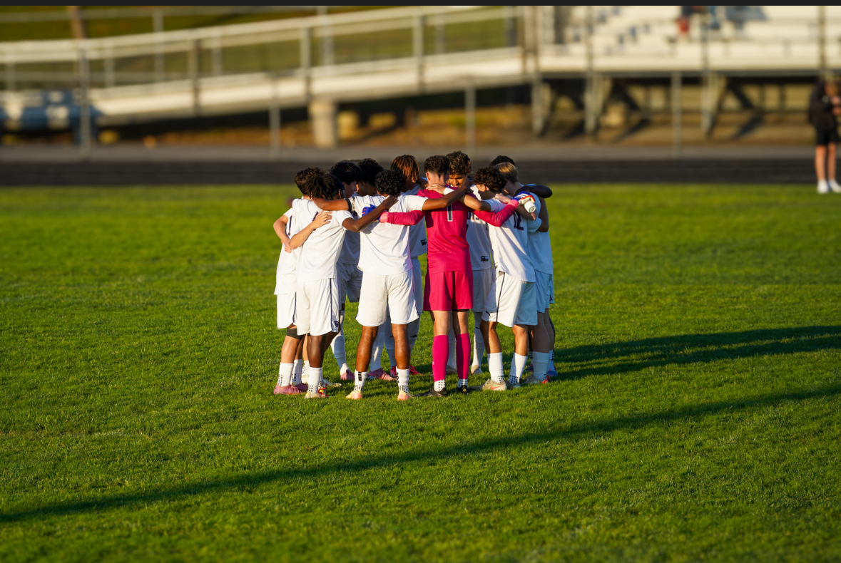 The boys' soccer team huddles up as the captains rally the team for their first game on Sept. 8 at Century High School. Photo by Claudia Chaduari