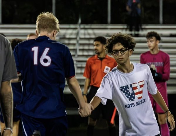 Class of 2025 graduate Daniel Yaya high athletes as they walk out before playing Northwood on Sept. 27, 2024. Yaya began working with the soccer team during his junior year. "He has been a big asset to the team, whether it is his unique tactics or individual tips," senior captain Kevin Sun said. Photo by Anton Obolensky