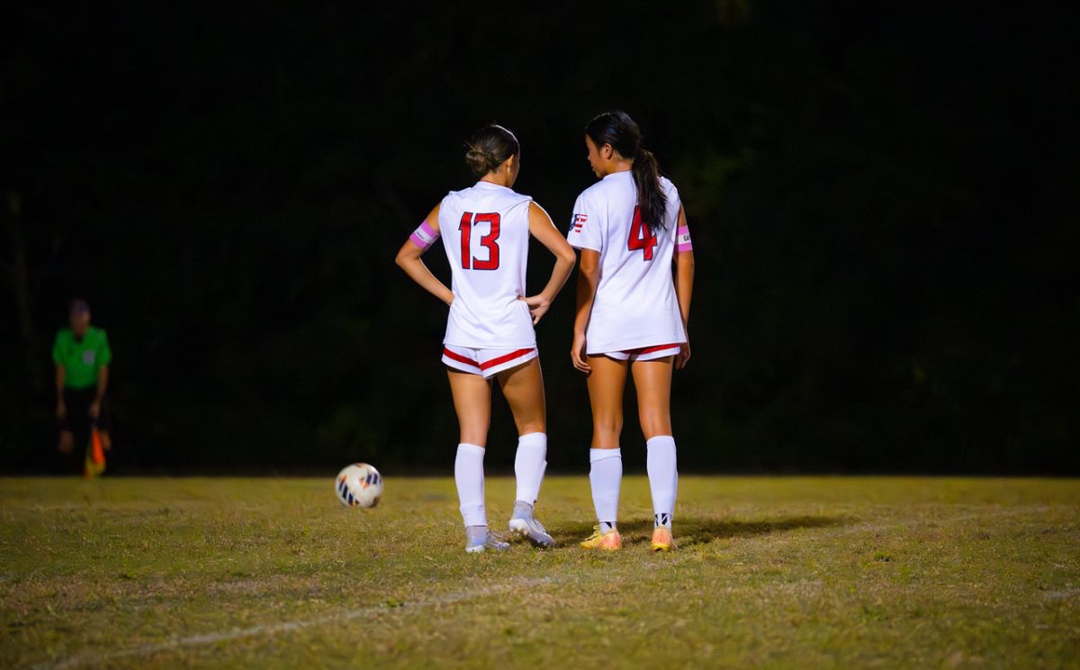 Senior captains Annalise Yi and Megan Lomotan talk about strategy for the free kick against the Magruder Colonels. "The Magruder game was an intense, high-energy game that ultimately ended in a thrilling overtime win for us. It built a lot of confidence and team spirit," Lomotan said. Photo courtesy Megan Lomotan