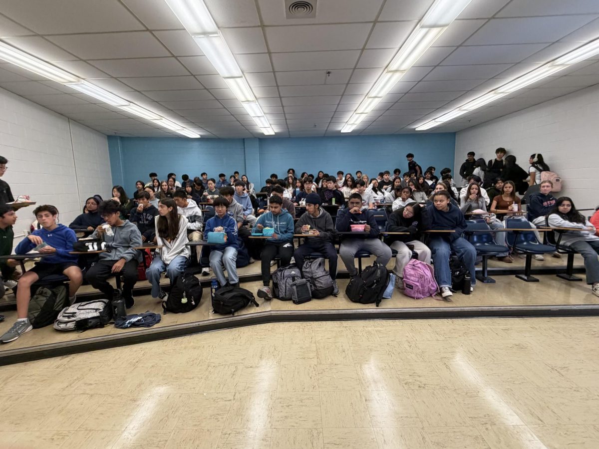 DECA members sit in the lecture hall on Oct. 16 and learn about the events that they can participate in during competitions. The meeting was especially informative to first-year members who are new to competing. Photo by Maria Thomas