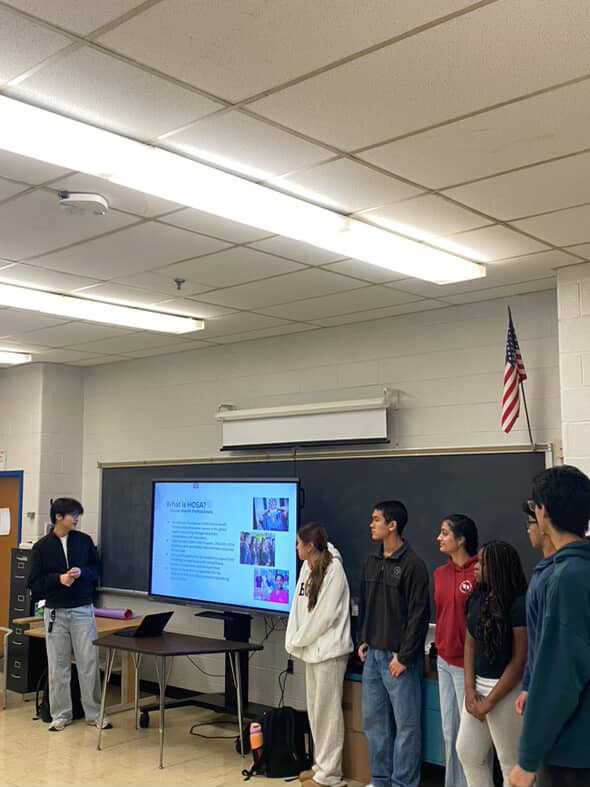 HOSA leadership presents an informational slideshow during a meeting in the lecture hall on Oct. 21. At the meeting, the club discussed upcoming events, member dues and more. Photo courtesy Michelle Liu