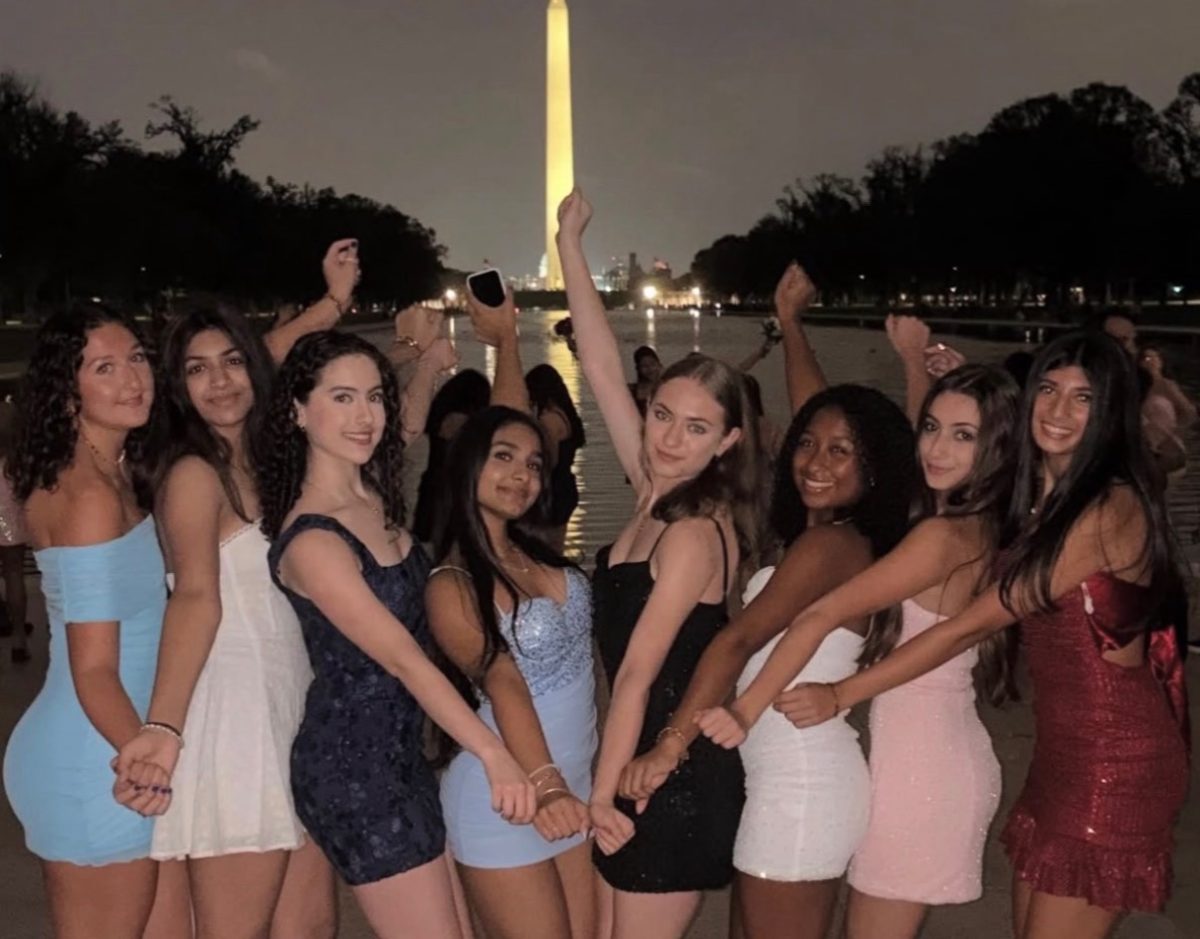 As it gets later on homecoming night, the Washington Monument attracts a glow making for a distinctive backdrop. Sophomore Justice Key and her friends take group pictures in front of the Washington Monument and shiny reflection on Oct. 11. Photo courtesy Justice Key