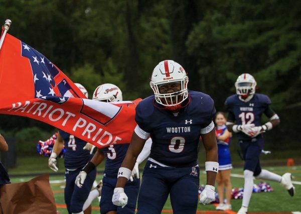 Junior Captain Jude Ampofo takes the field with teammates for game against Walter Johnson Wildcats. Photo by Keon Gray