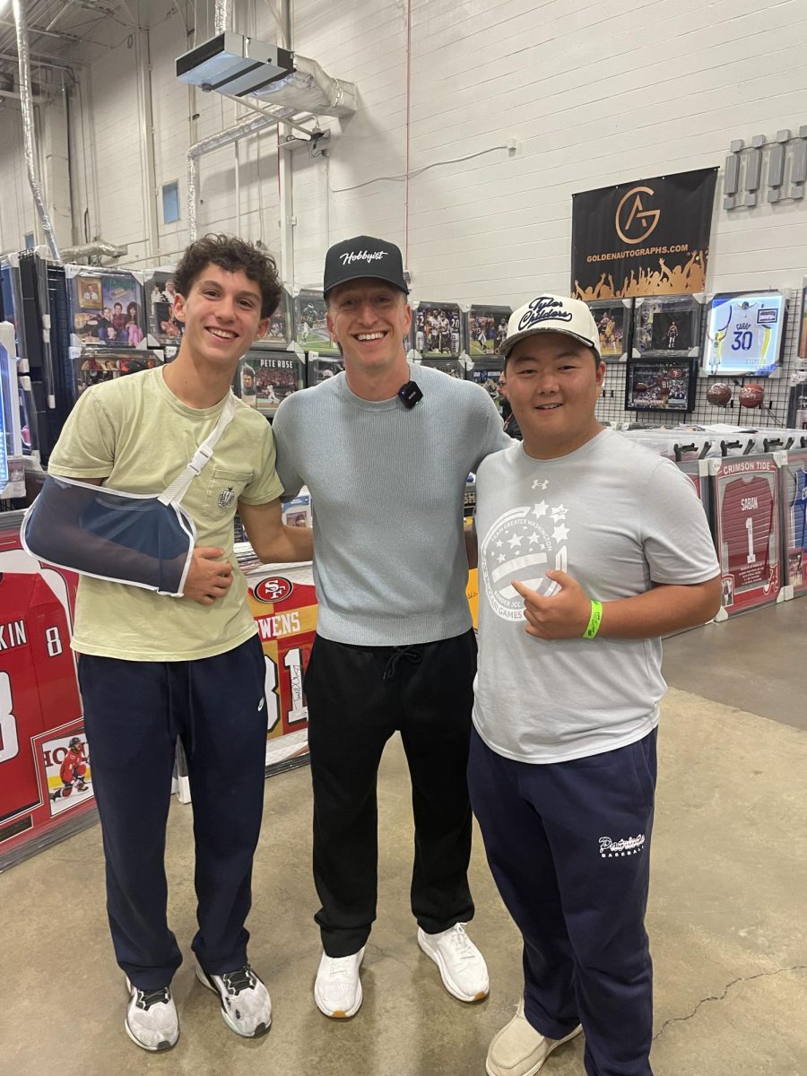 At the Dulles Expo Center card show, on Oct. 17, Kyle Kravitz, the King of Kards, was at the show making deals and filming for his social media channels. Junior Keon Grey (right) said it was an honor to make a deal with him and take a picture with him. Photo by Luca Phillips