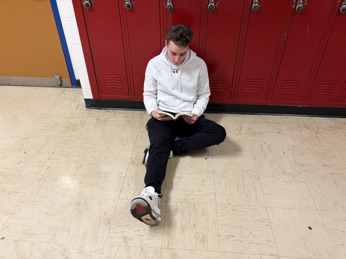 Senior Andrew Lord reads outside of his class during third period on Dec. 12. "I really only read books when I need to for school, when I'm on my own, I usually watch movies instead," senior Andrew Lord said.