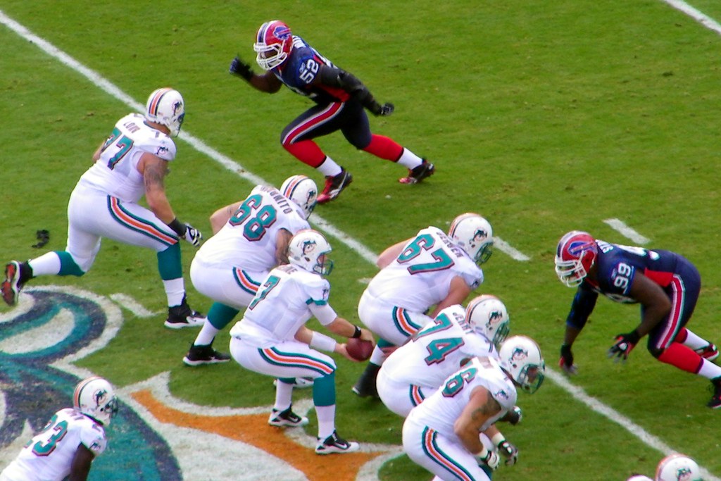 In 2013, the National Football League (NFL) reached a $765 million settlement with former players, who alleged the NFL was hiding the dangers of football, particularly in regards to concussions. Concussions and other injuries can result in Chronic Traumatic Encephalopathy (CTE), a common chronic issue that contact-sport players deal with in the long-term — and one that is often not clear to the public. "CTE results in a progressive decline of memory and cognition, as well as depression, suicidal behavior, poor impulse control, aggressiveness, Parkinsonism, and eventually dementia,” according to the National Library of Medicine. "Bills vs Dolphins 2010" by Alan Kotok is licensed under CC BY 2.0.