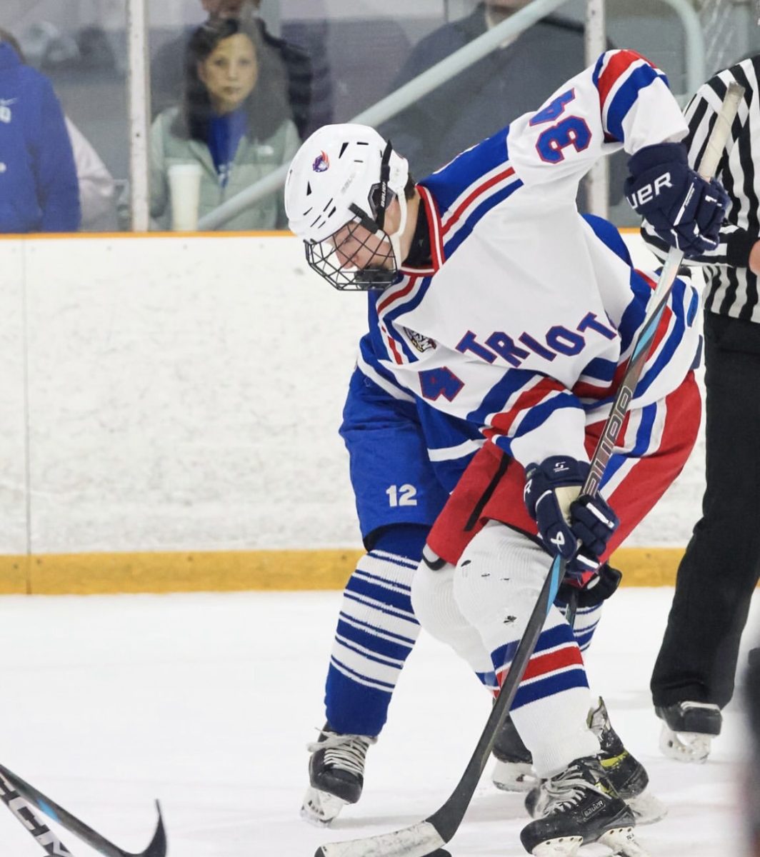 Senior Owen Goozh fights for a puck in his hockey game against the Sherwood Warriors on Dec.7. Goozh led the team to a victory over the Warriors 4-1 1. Photo by Sister Method