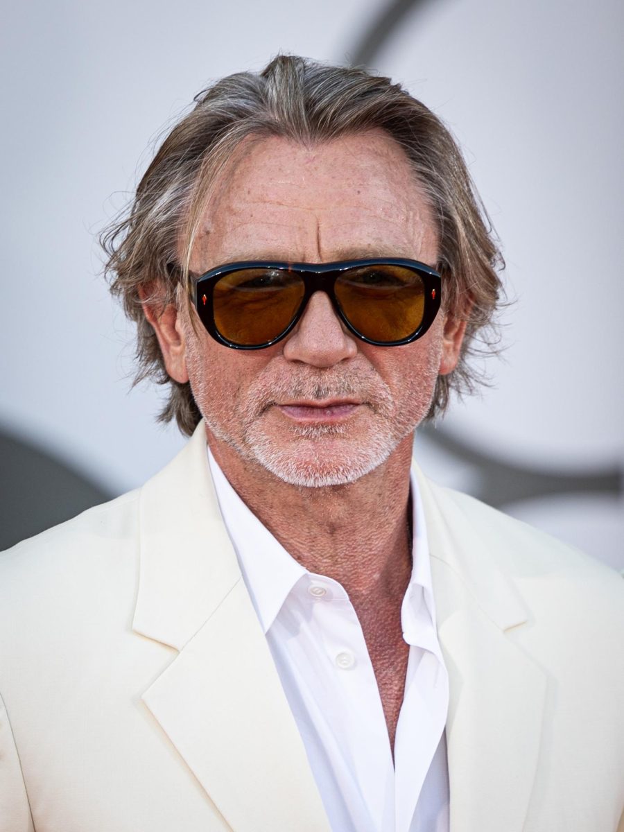 Daniel Craig plays as movies Benoit Blanc. "Wake Up Dead Man: A Knives Out Mystery" released in limited theaters on Nov. 26, 2025, then on Netflix on Dec. 12, 2025. The film follows detective Benoit Blanc, alongside pastor Jud Duplencity, as he tries to solve the "impossible" murder of Monsignor Jefferson Wicks, Duplencity's former colleague. "I'd recommend it. I'd recommend you watch all of them though, like watch the other two [Knives Out movies] first," senior Isabella Caban said. "Daniel Craig-62900" by Harald Krichel is licensed under CC BY-SA 4.0.