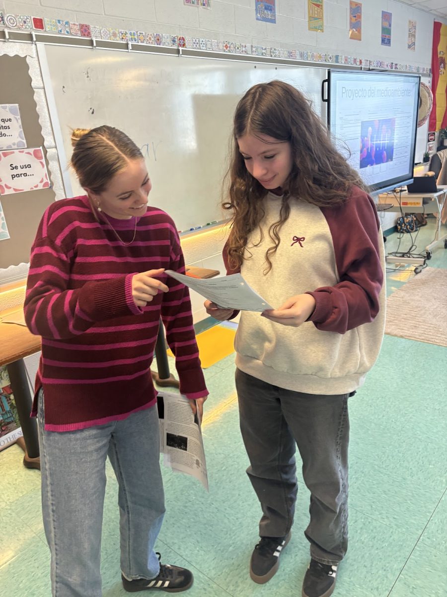 Spanish teacher Elsa Schoberg helps freshman Sophie Faberman with an assignment during period six on Feb. 25. Schoberg went on to help more students, staying with each student for two or three minutes, which is sometimes not enough time to ask all the questions they need. Faberman said, “I usually only get a few minutes of one-on-one time with my teacher per class period, maybe two-three minutes…it’s honestly not worth the hassle to [get a pass for advisory] just for a minor assignment.”