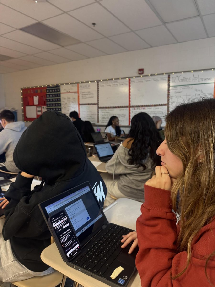 Senior Danielle Rubin is distracted by YouTube on her phone during English teacher Keisha Lambert's class, rather than doing a turn and talk discussion for the characterization notes Lambert is going over.