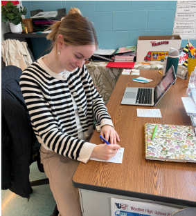 Spanish teacher Elsa Schoberg gives an after-school detention slip to a student. "I would rather get a lunch detention than an after school detention," sophomore Julia Sullivan said.