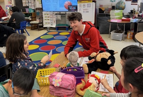 Sophomore Reed Gottesman helps students with drawings at Fallsmead Elementary school. "This season, I was super excited to hear about the opportunity to visit the Fallsmead students. It was really a full circle moment and I really took it all in when I went, remembering how I felt when I was there age," Gottesman said. Photo courtesy Reed Gottesman