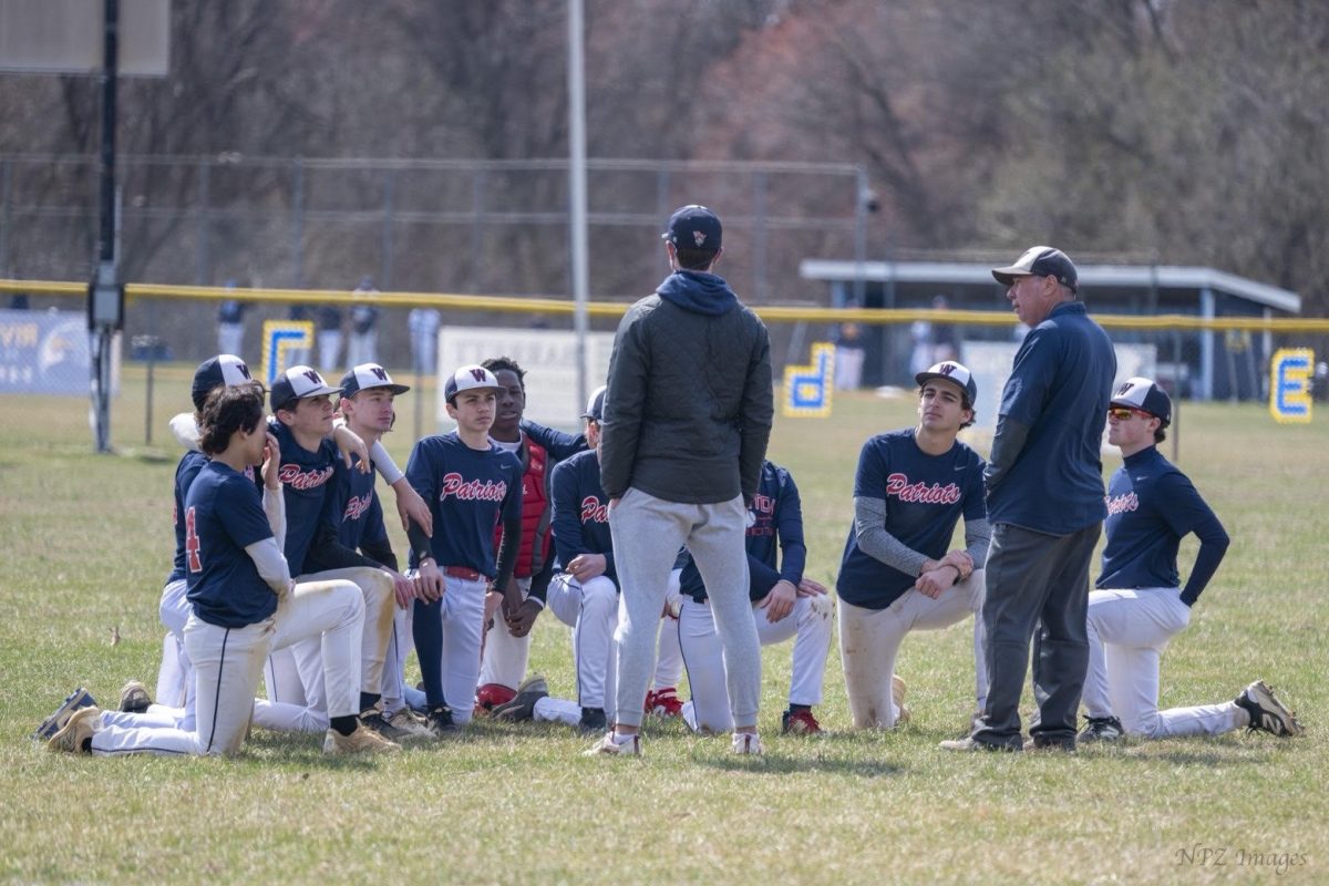 JV baseball coaches Nate Bowman and Matt Peffer congratulate the team after their win over River Hill High School on March 14. In the game, sophomore Jack Sisco hit a double and led the Patriots to a 7-3 win. Photo by Michael Neches
