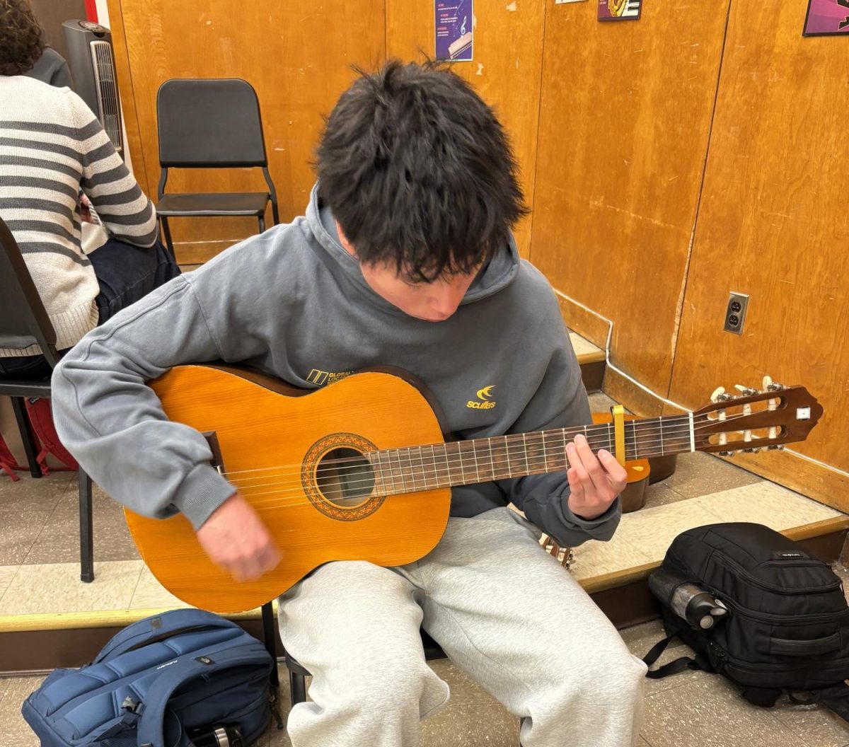 Senior Kevin Sun plays the guitar during his six period guitar class. Sun listens to a wide range of music and particularly enjoys country music, while also listening to rap. "I have always enjoyed Morgan Wallen the most but I listen to Hip Hop artists too," Sun said.
