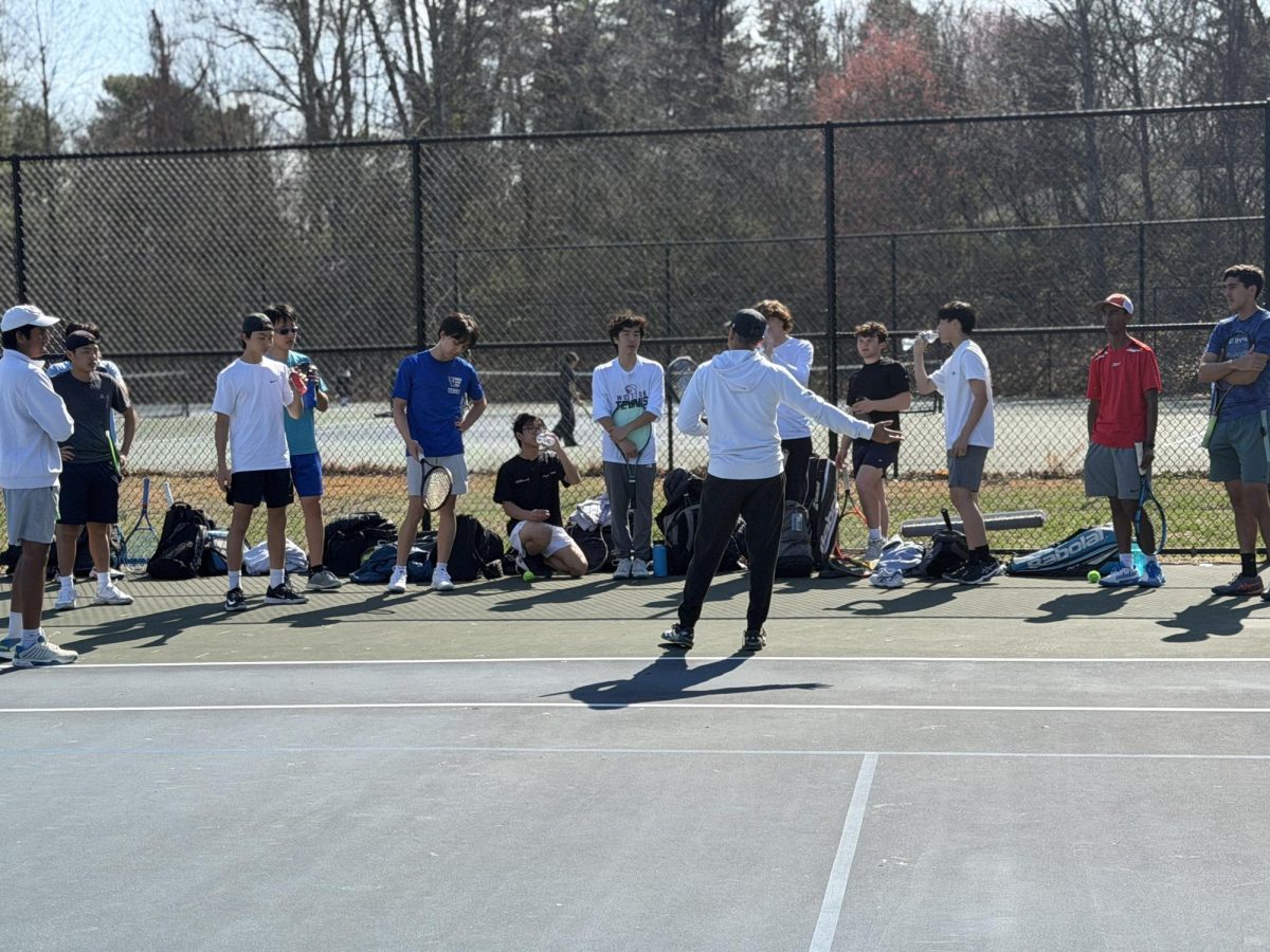 Boys' tennis Coach Nitin Deodhar gives a team talk during water break mid-way through the final March 18 practice before the first match the next day. “I believe that we can definitely win tomorrow,”  Deodhar said.