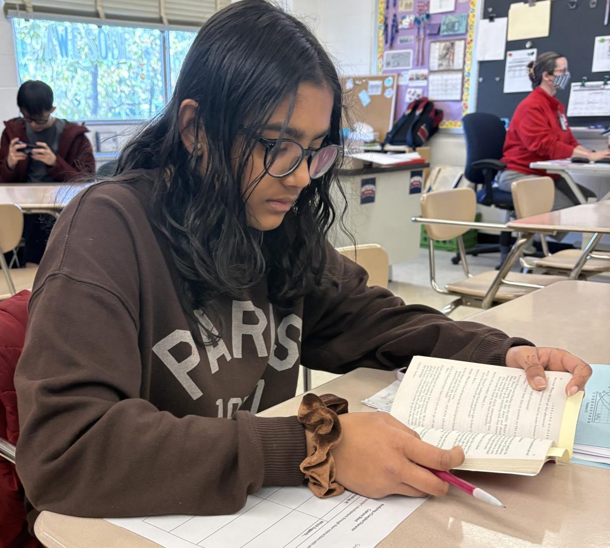 Freshman Shriya Ghosh finishes her English homework on Apr. 9 in Barbara Silcox’s class during homeroom. Ghosh is reading “A Raisin in the Sun” for Rachel Wilsdorf’s eighth period English nine class and is using this time to finish her character analysis homework assignment. “We’re reading the book A Raisin in the Sun and I need to find quotes of the interactions between characters,” Ghosh said.