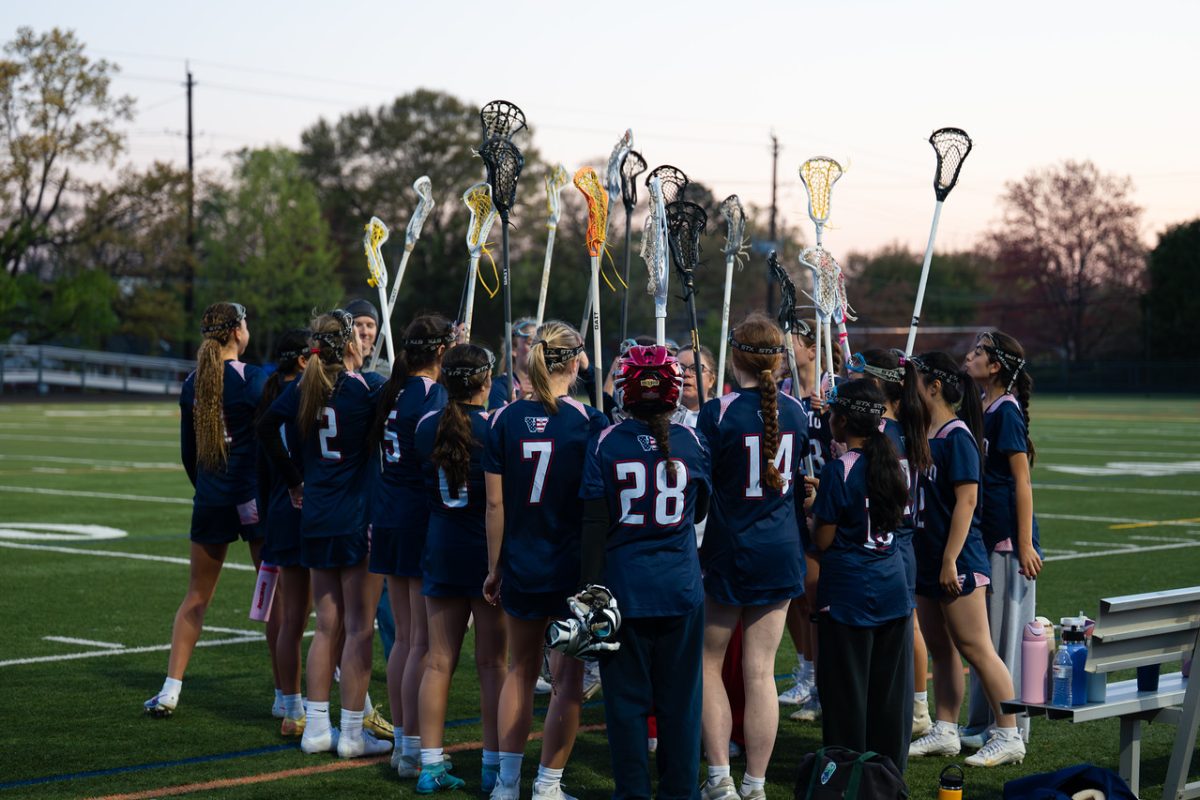 The varsity girls' lacrosse team gathers to talk over their game plan against Walter Johnson on April 9. Photo courtesy Kate Bardill