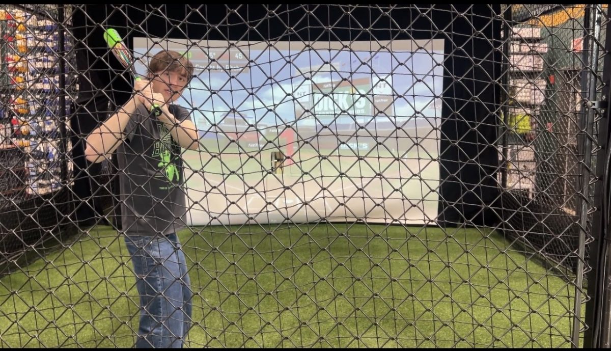 Junior Cody Brown steps into the indoor batting cage, trying out the experience during a visit. The interactive setup offers a fun way for students to engage with new activities in a relaxed environment. "It's actually really fun once you get the hang of it," Brown said. 