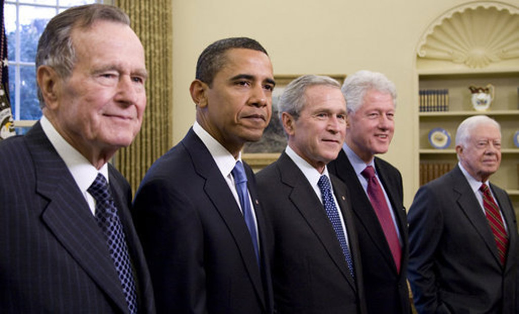 Five U.S. presidents — spanning multiple generations — stand together at the White House in 2009 during the presidential transition period. “2009 Five Presidents George W. Bush, President Elect Barack Obama, Former Presidents George H W Bush, Bill Clinton, Jimmy Carter Portrait” by Beverly & Pack is licensed by Public Domain Mark 1.0