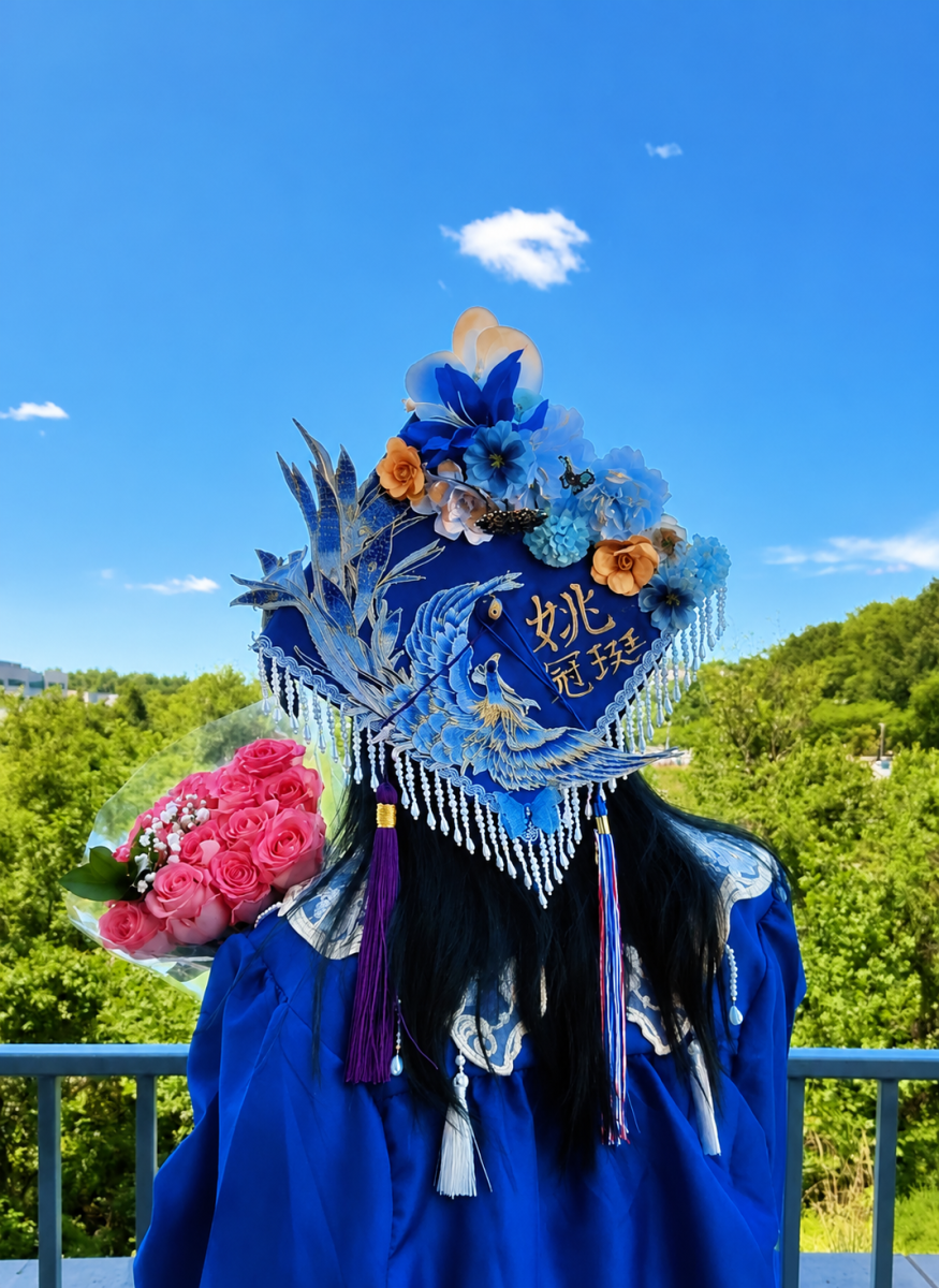Summer Yao’s graduation cap shows her Chinese heritage through symbols that are important to her. It includes a phoenix, flowers, butterflies, her Chinese name in gold, and a yin-yang symbol in the center. Each part has meaning connected to her identity and family. The butterflies also honor her late grandfather. Photo by Peter Yao